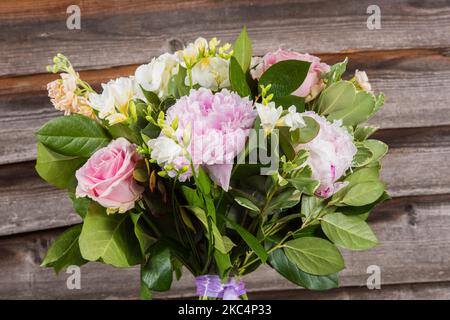 Un primo piano di una colorata bluebells texana e un bouquet di rose da giardino con sfondo in legno sfocato Foto Stock