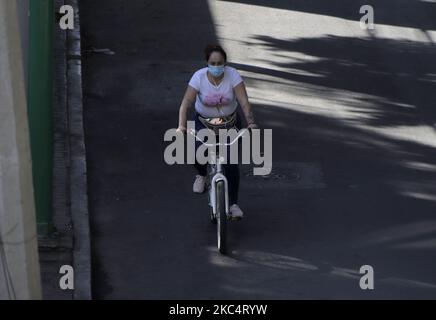 Un ciclista con una maschera per le strade di Città del Messico. Le autorità di Città del Messico hanno annunciato che il semaforo epidemiologico rimane arancione al limite del rosso perché il numero di persone ricoverate in ospedale per COVID-19 è aumentato nella capitale. Hanno riferito che per ridurre il numero di infezioni e ricoveri ospedalieri, le ore degli stabilimenti commerciali continueranno fino alle 7:00 per evitare la folla. (Foto di Gerardo Vieyra/NurPhoto) Foto Stock