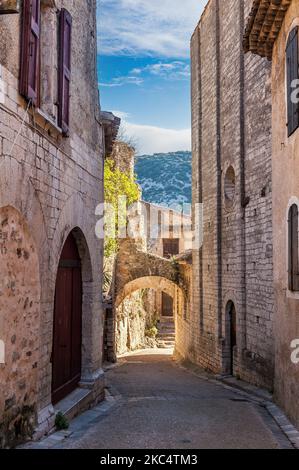 Strada stretta nel borgo medievale di Saint-Guilhem-le-désert, in Occitanie, Francia Foto Stock