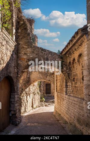 Strada stretta nel borgo medievale di Saint-Guilhem-le-désert, in Occitanie, Francia Foto Stock