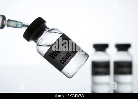 Una siringa medica e fiale con un adesivo che legge vaccino COVID-19 sono visti in questa foto creativa illustrativa. Oltre centocinquanta vaccini contro il coronavirus COVID-19 sono in sviluppo in tutto il mondo, molti dei quali hanno la terza fase di studi clinici, come riportato dai media. (Foto di Str/NurPhoto) Foto Stock