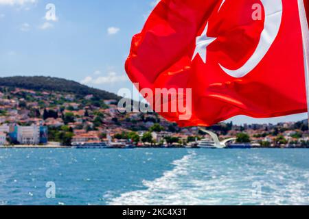 Bandiera turca che sventola su un traghetto turistico in partenza dal porto dell'isola di Heybeliada, la 2nd più grande delle isole del Principe nel mare di Marmara, Turchia. Foto Stock