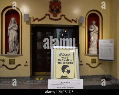 Un cartello con la scritta "Please wear face Mask or Face Cover" visto all'ingresso della Whitefriar Street Church, nel centro di Dublino. Taoiseach (PM irlandese) Micheal Martin ha annunciato venerdì scorso piani per l'allentamento delle restrizioni di blocco a livello nazionale di livello 5 e la riapertura del paese per un certo numero di fasi da domani nel periodo precedente a Natale. La prima fase vedrà tutti i negozi, parrucchieri, palestre, cinema, musei, possibilità di riaprire gallerie e biblioteche. I luoghi di culto riapriranno per i servizi con misure restrittive, mentre riunioni di 15 persone possono avere luogo all'aperto. Lunedì, Foto Stock