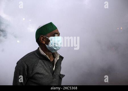 Gli agricoltori si riuniscono lungo una strada, in mezzo al fumo durante la fumigazione da parte della società municipale, vicino a un blocco stradale che impedisce agli agricoltori di marciare verso la capitale nazionale per protestare contro le recenti riforme agricole del govt centrale al confine di stato Delhi-Uttttar Pradesh a Ghazipur il 1 dicembre 2020. (Foto di Mayank Makhija/NurPhoto) Foto Stock