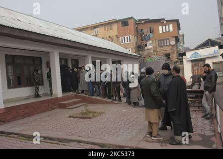 Le persone sono in fila fuori una cabina di voto duirng seconda fase della DDC, ULP elezioni a Srinagar, indiano amministrato Kashmir il 01 dicembre 2020. Seconda fase del consiglio di sviluppo Distrettuale, l'elezione degli enti locali urbani si è svolta in molte constuienze in Jammu e Kashmir. La percentuale di voto finale per la seconda fase delle elezioni DDC è del 48,62%, del 65,54% in Jammu e del 33,34% nella valle del Kashmir. (Foto di Muzamil Mattoo/NurPhoto) Foto Stock