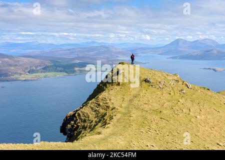 Un camminatore sulla cresta sommitale di ben Tianavaig che guarda sopra il suono interno alle colline di Cuillin Rosso. Vicino a Portree, Isola di Skye, Scozia, Regno Unito Foto Stock