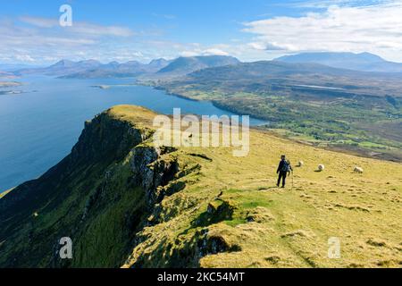 Un camminatore sulla cresta sommitale di ben Tianavaig che guarda sopra il suono interno alle colline di Cuillin. Vicino a Portree, Isola di Skye, Scozia, Regno Unito Foto Stock