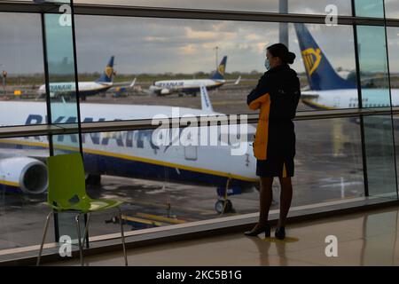 Un membro dell'equipaggio di cabina Ryanair guarda fuori dalla finestra agli aerei Ryanair che si sono messi a terra all'aeroporto di Dublino, durante il blocco del coronavirus livello 3. La pandemia ha avuto un impatto 'disastante' sull'operatore dell'aeroporto di Dublino. Secondo Dalton Philips, le perdite di DAA all'inizio di settembre 2020 si avvicinavano ai €150 milioni di dollari. Molti aeroporti in tutta l'Unione europea sono ora sottoposti a forti pressioni finanziarie a causa del crollo del numero di passeggeri a causa della pandemia di Covid. Sabato 05 dicembre 2020, all'aeroporto di Dublino Dublino, Irlanda. (Foto di Artur Widak/NurPhoto) Foto Stock