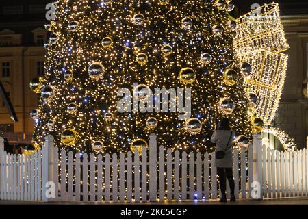 Una donna scatta foto di un albero di Natale e delle decorazioni fuori dal centro commerciale Galeria Krakowska di Cracovia. Domenica 6 dicembre 2020 a Cracovia, Polonia. (Foto di Artur Widak/NurPhoto) Foto Stock