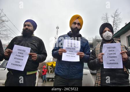 La gente tiene cartelli di solidarietà nei confronti degli agricoltori che protestano a Srinagar, l'indiano ha amministrato il Kashmir il 08 dicembre 2020. Gli agricoltori indiani hanno protestato contro i nuovi conti agricoli e hanno bloccato le strade ai confini di Nuova Delhi per costringere il governo ad abrogare lo stesso. (Foto di Muzamil Mattoo/NurPhoto) Foto Stock