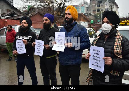 La gente tiene cartelli di solidarietà nei confronti degli agricoltori che protestano a Srinagar, l'indiano ha amministrato il Kashmir il 08 dicembre 2020. Gli agricoltori indiani hanno protestato contro i nuovi conti agricoli e hanno bloccato le strade ai confini di Nuova Delhi per costringere il governo ad abrogare lo stesso. (Foto di Muzamil Mattoo/NurPhoto) Foto Stock