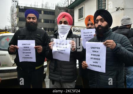 La gente tiene cartelli di solidarietà nei confronti degli agricoltori che protestano a Srinagar, l'indiano ha amministrato il Kashmir il 08 dicembre 2020. Gli agricoltori indiani hanno protestato contro i nuovi conti agricoli e hanno bloccato le strade ai confini di Nuova Delhi per costringere il governo ad abrogare lo stesso. (Foto di Muzamil Mattoo/NurPhoto) Foto Stock