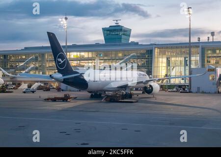 Lufthansa Airbus A350 e il Terminal dell'aeroporto visto la mattina presto all'alba, all'alba e durante il giorno parcheggiato alle porte dell'aeroporto internazionale di Monaco EDDM MUC. Il moderno e avanzato velivolo da A359 o A350-900 passeggeri a scocca larga è dotato della targa D-AIXO, il nome Ulm, ed è alimentato da motori a reazione 2x RR. Deutsche Lufthansa AG DLH o LH è la più grande compagnia aerea in Germania, con base hub a Francoforte, Monaco e Berlino, ex vettore di bandiera tedesco e membro fondatore del gruppo aereo della Star Alliance. Il traffico mondiale di passeggeri è diminuito durante il coronaviru Foto Stock