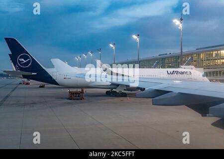 Lufthansa Airbus A350 e il Terminal dell'aeroporto visto la mattina presto all'alba, all'alba e durante il giorno parcheggiato alle porte dell'aeroporto internazionale di Monaco EDDM MUC. Il moderno e avanzato velivolo da A359 o A350-900 passeggeri a scocca larga è dotato della targa D-AIXO, il nome Ulm, ed è alimentato da motori a reazione 2x RR. Deutsche Lufthansa AG DLH o LH è la più grande compagnia aerea in Germania, con base hub a Francoforte, Monaco e Berlino, ex vettore di bandiera tedesco e membro fondatore del gruppo aereo della Star Alliance. Il traffico mondiale di passeggeri è diminuito durante il coronaviru Foto Stock