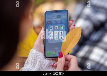 Kiev, Ucraina - 4 novembre 2022. Le applicazioni Microsoft 365 sono visibili su un iPhone tenuto da una ragazza in background - Office, Word, Excel, PowerPoi Foto Stock