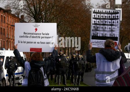 I membri della Lega per i diritti umani cartelli brandiscono davanti alla polizia antisommossa (CRS) che recita "riconoscimento facciale: Controllo permanente dell'identità". Migliaia di manifestanti hanno marciato di nuovo contro la legge sulla "legge sulla sicurezza globale" promossa dal presidente francese Macron e dalla sua maggioranza e per ottenere più mezzi per il sistema sanitario pubblico e gli ospedali. Il disegno di legge 'Global Security Law' proibirà a chiunque di fotografare o filmare i membri della polizia se non violati : i trasgressori potrebbero essere condannati fino a un anno in prigione e una multa di €45,000 dollari. La legge prevede anche di generalizzare il riconoscimento facciale negli spazi pubblici come in Cina. La Fre Foto Stock