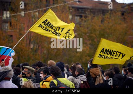 Bandiere della ONG Amnesty International. Migliaia di manifestanti hanno marciato di nuovo contro la legge sulla "legge sulla sicurezza globale" promossa dal presidente francese Macron e dalla sua maggioranza e per ottenere più mezzi per il sistema sanitario pubblico e gli ospedali. Il disegno di legge 'Global Security Law' proibirà a chiunque di fotografare o filmare i membri della polizia se non violati : i trasgressori potrebbero essere condannati fino a un anno in prigione e una multa di €45,000 dollari. La legge prevede anche di generalizzare il riconoscimento facciale negli spazi pubblici come in Cina. Il difensore dei diritti francesi, la Commissione nazionale francese per i diritti dell'uomo (organi amministrativi) e l'U Foto Stock