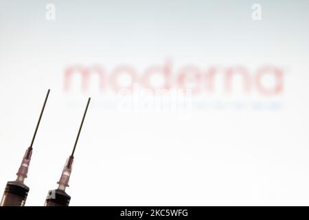 Immagine di una siringa medica con un ago visto davanti al logo della società farmaceutica moderna. Moderna si aspetta la decisione americana, un'approvazione per l'uso di emergenza, il vaccino candidato mRNA-1273 il 17 2020 dicembre dalla FDA e l'approvazione europea per il vaccino COVID-19 nel gennaio del 2021. Moderna è una società di biotecnologia americana con sede a Cambridge, Massachusetts, che sviluppa tecnologie vaccinali basate sull'mRNA messaggero. La pandemia di Coronavirus, una delle più grandi crisi sanitarie del mondo, porterà al più grande programma di vaccinazione nella storia umana. Amste Foto Stock