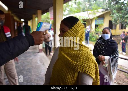 Gli elettori sono sottoposti a screening termico in attesa di esprimere i loro voti per le elezioni del Consiglio autonomo di Tiwa 2020 nel distretto di Nagaon, nello stato nordorientale di Assam, India, 17,2020 dicembre (Foto di Anuwar Hazarika/NurPhoto) Foto Stock