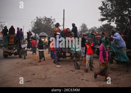 I lavoratori sono in piedi sui veicoli mentre vanno a lavorare in una mattinata di inizio inverno a Dhaka, Bangladesh, venerdì 18 dicembre 2020. (Foto di Syed Mahamudur Rahman/NurPhoto) Foto Stock