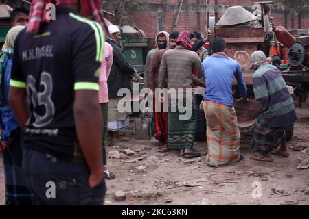 Gli operai tirano un veicolo mentre vanno a lavorare in una mattina di inizio inverno a Dhaka, Bangladesh venerdì 18 dicembre 2020. (Foto di Syed Mahamudur Rahman/NurPhoto) Foto Stock