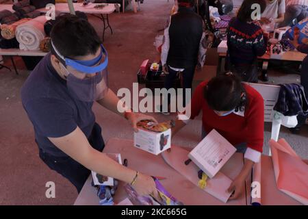 Volontari e membri della Comunità di Sant'Egidio in Messico, giocattoli avvolgenti da consegnare alle popolazioni di strada e a rischio, la vigilia di Natale a Città del Messico durante l'emergenza sanitaria dovuta al COVID-19 e il ritorno del semaforo epidemiologico rosso nella capitale. (Foto di Gerardo Vieyra/NurPhoto) Foto Stock