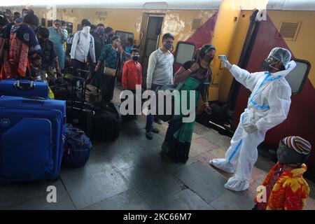 Un operatore sanitario controlla la temperatura dei passeggeri per testare la pandemia COVID-19 in una stazione ferroviaria di Mumbai, India il 20 dicembre 2020 (Foto di Himanshu Bhatt/NurPhoto) Foto Stock