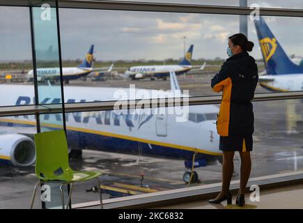 Un membro dell'equipaggio di cabina Ryanair guarda fuori dalla finestra gli aerei Ryanair a terra all'aeroporto di Dublino (immagine del file dicembre 5). A partire dalla mezzanotte tutti i voli e i traghetti passeggeri dalla Gran Bretagna all'Irlanda saranno sospesi per un periodo iniziale di 48 ore, nel tentativo di fermare la diffusione di un nuovo ceppo di coronavirus in Irlanda. Domenica 20 dicembre 2020 a Dublino, Irlanda. (Foto di Artur Widak/NurPhoto) Foto Stock