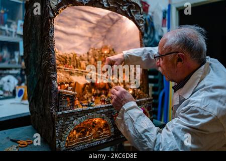 Presepe in costruzione di Giuseppe Magarelli, uno dei più antichi artigiani della Molfetta, nella sua bottega a Molfetta il 24 dicembre 2020. Uno dei più storici artigiani presepi di Molfetta, Giuseppe Magarelli, 68 anni, idraulico, che da 50 anni produce presepi fatti a mano come hobby, membro dell'Associazione Italiana amici della Natività. La sua più grande presepe è lunga 2,20 metri, alta 2,70 metri e profonda 1,70 metri. Ha iniziato a fare presepi con suo padre 50 anni fa e ogni anno, aggiunge o modifica alcune parti, anche facendo tutti i movimenti meccanici ai personaggi. Foto Stock