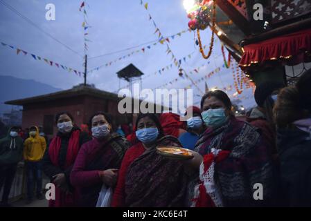 I devoti nepalesi insieme alla maschera facciale arrivano per offrire la preghiera rituale durante il festival Saat Gaule Jatra, nella prima mattina a Tinthana, Kathmandu, Nepal, giovedì 24 dicembre 2020. Saat Gaule Jatra si celebra ogni anno in occasione dell'arrivo dell'inverno. (Foto di Narayan Maharjan/NurPhoto) Foto Stock