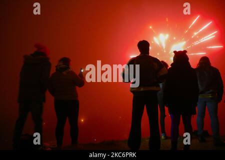 La gente osserva i fuochi d'artificio durante la vigilia di Capodanno a Cracovia, in Polonia. Gennaio 1st, 2021. A causa della diffusione della pandemia di coronavirus, Mateusz Morawiecki, il primo ministro polacco ha fatto appello al popolo polacco affinché non si spostasse e non partecipasse alle riunioni dal 19,00 dicembre 31 al 06,00 gennaio 1. (Foto di Beata Zawrzel/NurPhoto) Foto Stock