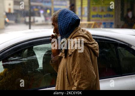 Un uomo fuma 'bidi' una piccola mano arrotolata sigaretta durante la pioggia in Ajmer, lo Stato indiano di Rajasthan il 04 gennaio 2021. (Foto di Himanshu Sharma/NurPhoto) Foto Stock