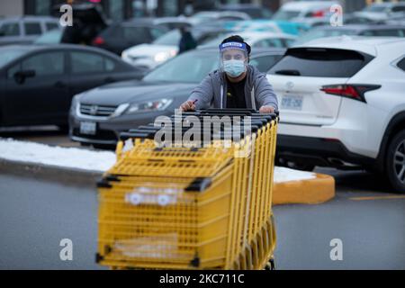 Un uomo spinge carrelli con maschera di protezione contro il coronavirus a Toronto, Canada, 05 gennaio 2021. Public Health Ontario ha segnalato 3.128 nuovi casi di COVID-19 oggi. La provincia ha riportato 51 morti nell'aggiornamento di oggi. Di questi, 22 erano residenti di case di cura a lungo termine. (Foto di Sayed Najafizada/NurPhoto) Foto Stock