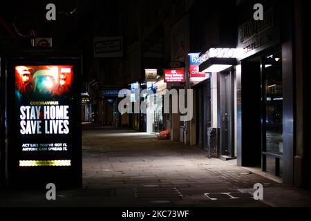 I messaggi del governo che dicono alle persone di rimanere a casa illuminano lo schermo della pubblicità digitale di una fermata dell'autobus su uno Strand vicino deserto a Londra, Inghilterra, il 7 gennaio 2021. All'inizio di questa settimana l'Inghilterra ha iniziato un terzo blocco nazionale del coronavirus, con la preoccupazione delle autorità di far sì che il Servizio sanitario Nazionale (NHS) possa presto essere sopraffatto dai malati di covid-19. Nel frattempo, il primo ministro britannico Boris Johnson ha annunciato oggi che 1,5m persone in tutto il Regno Unito hanno ricevuto almeno una prima dose di vaccino covid-19, con piani per centinaia di migliaia di vaccinazioni da somministrare ogni giorno Foto Stock