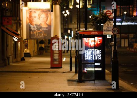 I messaggi del governo che dicono alle persone di rimanere a casa illuminano lo schermo della pubblicità digitale di una fermata dell'autobus su un Haymarket quasi deserto a Londra, Inghilterra, il 7 gennaio 2021. All'inizio di questa settimana l'Inghilterra ha iniziato un terzo blocco nazionale del coronavirus, con la preoccupazione delle autorità di far sì che il Servizio sanitario Nazionale (NHS) possa presto essere sopraffatto dai malati di covid-19. Nel frattempo, il primo ministro britannico Boris Johnson ha annunciato oggi che 1,5m persone in tutto il Regno Unito hanno ricevuto almeno una prima dose di vaccino covid-19, con piani per centinaia di migliaia di vaccinazioni da somministrare ogni giorno f Foto Stock