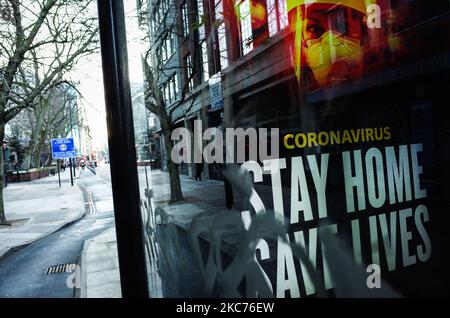 I messaggi del governo che dicono alle persone di rimanere a casa sono esposti presso una fermata dell'autobus coperta da graffiti a Whitechapel a Londra, in Inghilterra, il 9 gennaio 2021. L'Inghilterra ha iniziato un terzo blocco nazionale martedì in un tentativo di arginare la trasmissione del coronavirus in tutto il paese. Nella capitale, il sindaco di Londra Sadiq Khan ha dichiarato ieri un 'incidente principale' per la città sulle pressioni di coronavirus, avvertendo che gli ospedali potrebbero presto essere sopraffatti con pazienti con covid-19. (Foto di David Cliff/NurPhoto) Foto Stock