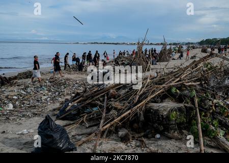 Centinaia di abitanti del villaggio di Jimbaran hanno lavorato insieme per ripulire decine di tonnellate di rifiuti bloccati a Muaya Beach, il 10 gennaio 2021. Questa condizione ambientale si verifica quasi ogni anno durante la stagione delle piogge, soprattutto all'inizio del nuovo anno a causa del monsone occidentale, che porta spazzatura dalla zona occidentale di Bali alla costa occidentale di Bali. (Foto di Keyza Widiatmika/NurPhoto) Foto Stock