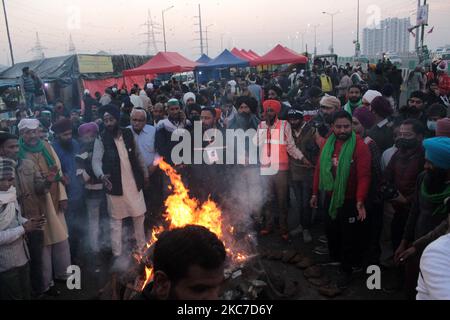 Gli agricoltori che protestano celebrano il festival di Lohri intorno a un falò, mentre bloccano una grande autostrada in protesta contro le nuove leggi agricole al confine di stato Delhi-Utttar Pradesh vicino Ghazipur alla periferia di Nuova Delhi, India il 13 gennaio 2021. Decine di migliaia di agricoltori protestano per 49 giorni presso i punti di ingresso principali della capitale nazionale. (Foto di Mayank Makhija/NurPhoto) Foto Stock