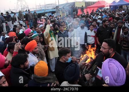 Gli agricoltori che protestano celebrano il festival di Lohri intorno a un falò, mentre bloccano una grande autostrada in protesta contro le nuove leggi agricole al confine di stato Delhi-Utttar Pradesh vicino Ghazipur alla periferia di Nuova Delhi, India il 13 gennaio 2021. Decine di migliaia di agricoltori protestano per 49 giorni presso i punti di ingresso principali della capitale nazionale. (Foto di Mayank Makhija/NurPhoto) Foto Stock
