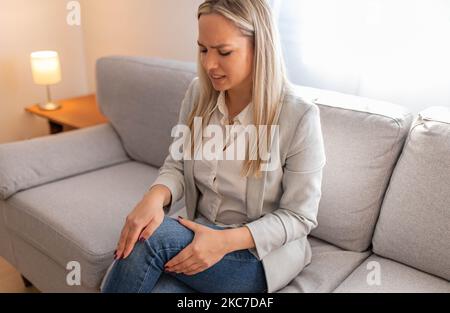Donna che soffrono di dolore al ginocchio Foto Stock