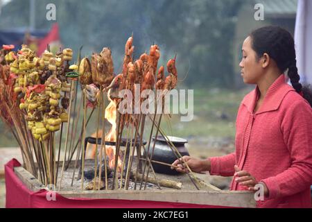 Il cibo tradizionale assamese viene preparato per la vendita in occasione della celebrazione del festival Magh Bihu nel distretto di Nagaon di Assam, in India, il 14,2021 gennaio. Magh Bihu è la festa del raccolto del nord-est dello stato di Assam ed è osservato nel mese assamese di Magh, che coincide con gennaio (Foto di Anuwar Hazarika/NurPhoto) Foto Stock