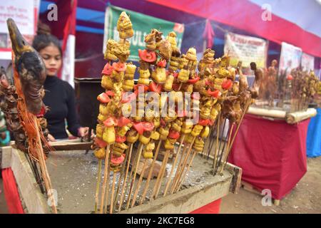 Il cibo tradizionale assamese viene preparato per la vendita in occasione della celebrazione del festival Magh Bihu nel distretto di Nagaon di Assam, in India, il 14,2021 gennaio. Magh Bihu è la festa del raccolto del nord-est dello stato di Assam ed è osservato nel mese assamese di Magh, che coincide con gennaio (Foto di Anuwar Hazarika/NurPhoto) Foto Stock