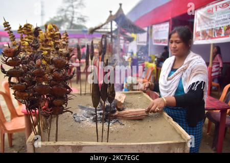 Il cibo tradizionale assamese viene preparato per la vendita in occasione della celebrazione del festival Magh Bihu nel distretto di Nagaon di Assam, in India, il 14,2021 gennaio. Magh Bihu è la festa del raccolto del nord-est dello stato di Assam ed è osservato nel mese assamese di Magh, che coincide con gennaio (Foto di Anuwar Hazarika/NurPhoto) Foto Stock