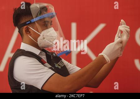 Il medico prepara una dose di vaccino Sinovac COVID-19 prima di somministrare un shot in un ospedale di Denpasar, Bali, Indonesia il 14 2021 gennaio. L'Indonesia inizia ad attuare il programma di vaccinazione COVID-19 per gli operatori sanitari e i funzionari governativi nella prima fase del programma di vaccinazione nazionale. Il governo ha ordinato 125 milioni di dosi di vaccino dalla Sinovac Biotech cinese. (Foto di Johanes Christo/NurPhoto) Foto Stock