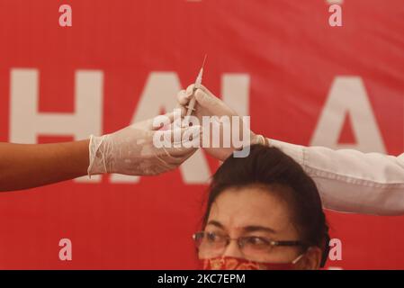Il medico prepara una dose di vaccino Sinovac COVID-19 prima di somministrare un shot in un ospedale di Denpasar, Bali, Indonesia il 14 2021 gennaio. L'Indonesia inizia ad attuare il programma di vaccinazione COVID-19 per gli operatori sanitari e i funzionari governativi nella prima fase del programma di vaccinazione nazionale. Il governo ha ordinato 125 milioni di dosi di vaccino dalla Sinovac Biotech cinese. (Foto di Johanes Christo/NurPhoto) Foto Stock