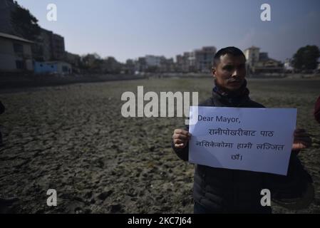 Un gruppo di attivisti del patrimonio ha messo in scena una protesta simbolica insieme a cartelli contro la costruzione di strutture in cemento intorno al secolare laghetto Kamalpokhari a Kathmandu, Nepal, venerdì 15 gennaio 2021. Kamalpokhari stagno è asciugato per la costruzione di strutture in cemento intorno. (Foto di Narayan Maharjan/NurPhoto) Foto Stock