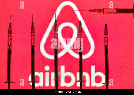 Immagine illustrativa delle siringhe mediche davanti al logo Airbnb visualizzato su uno schermo. Lunedì 18 gennaio 2021 a Dublino, Irlanda. (Foto di Artur Widak/NurPhoto) Foto Stock