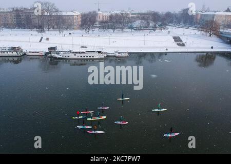 Una vista aerea su un gruppo di SUP boarders sul fiume Vistola in una giornata invernale innevata a Cracovia, Polonia, il 17 gennaio 2021. Il paddleboarding è diventato popolare a Cracovia dopo la continua chiusura delle piscine pubbliche, delle palestre e di altri centri sportivi a causa della diffusione del coronavirus. (Foto di Beata Zawrzel/NurPhoto) Foto Stock