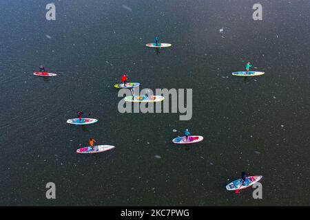 Una vista aerea su un gruppo di SUP boarders sul fiume Vistola in una giornata invernale innevata a Cracovia, Polonia, il 17 gennaio 2021. Il paddleboarding è diventato popolare a Cracovia dopo la continua chiusura delle piscine pubbliche, delle palestre e di altri centri sportivi a causa della diffusione del coronavirus. (Foto di Beata Zawrzel/NurPhoto) Foto Stock