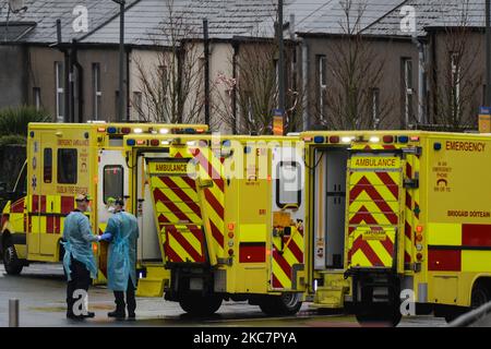 Due paramedici visti vicino alle ambulanze parcheggiate al di fuori del dipartimento A ed e presso il Mater Misericordiae University Hospital di Dublino, durante la terza chiusura nazionale dell'Irlanda. Il servizio sanitario irlandese sta affrontando potenzialmente la settimana più impegnativa della sua storia, con un forte aumento del numero di pazienti Covid-19 che necessitano di cure intensive dalla fine di dicembre. Il Dipartimento della Salute ha riferito questa sera 1.975 pazienti Covid-19 erano in ospedale con il virus in tutto il paese, di cui 200 sono in terapia intensiva. Lunedì 18 gennaio 2021 a Dublino, Irlanda. (Foto Foto Stock